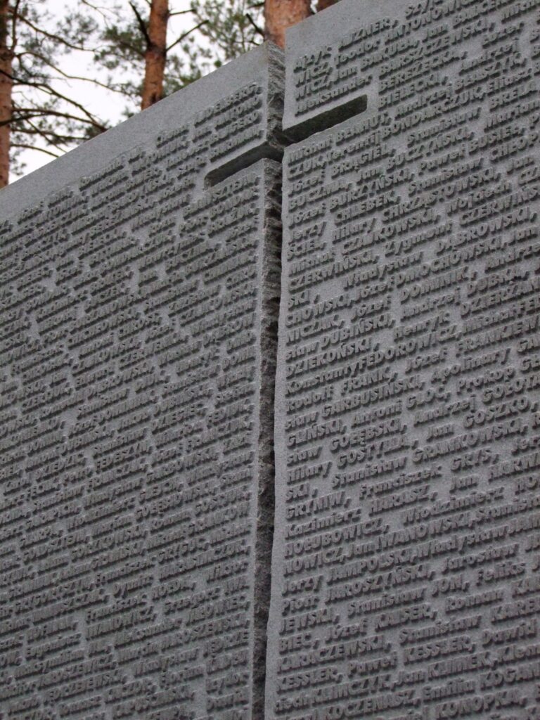 Kamienna tablica z krzyżem i wyrytymi nazwiskami.