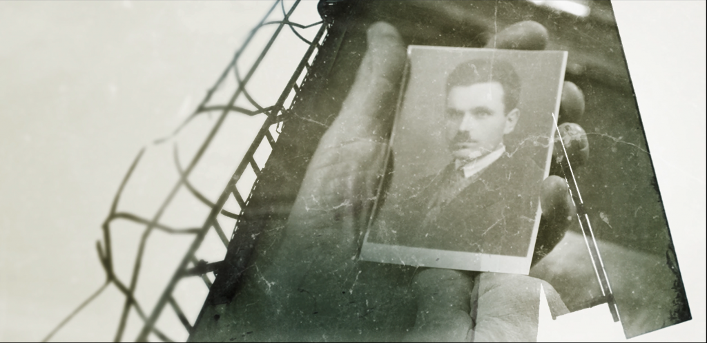 Ręce trzymające fotografię - portret mężczyzny w garniturze.