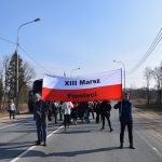 Młodzież idąca po ulicy z transparentem w barwach polskich z napisem "XIII Marsz Pamięci".