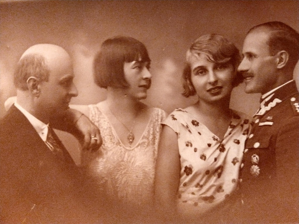 Zdjęcie w sepi, dwie kobiety , mężczyzna w garniturze i mężczyzna w mundurze.